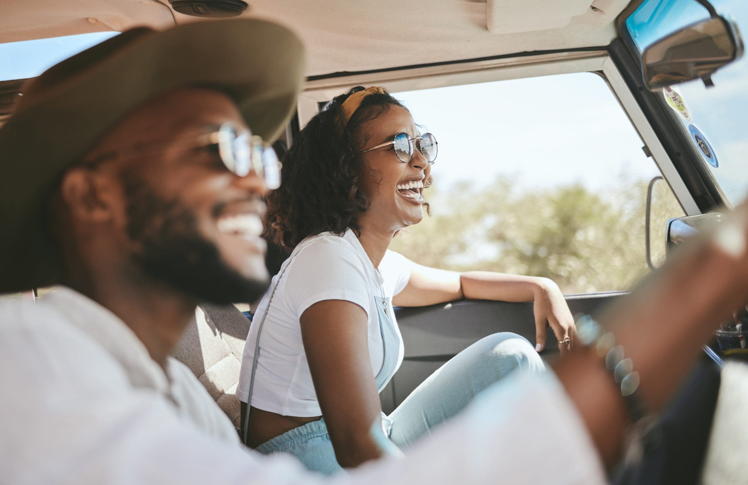 Homme et femme souriant dans une voiture